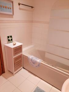 un baño con bañera y lavabo en Verde Ria apartamento, en Torreira