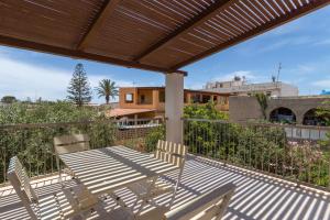 un patio con tavolo e sedie sul balcone. di Case Vacanze Maluk a Lampedusa