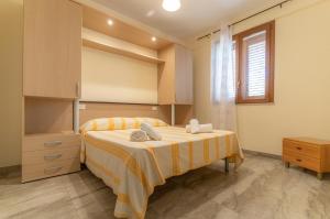 a bedroom with a large bed and a window at Case Vacanze Maluk in Lampedusa