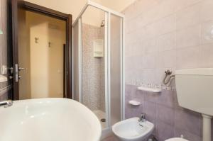 La salle de bains est pourvue de toilettes blanches et d'un lavabo. dans l'établissement Case Vacanze Maluk, à Lampedusa