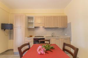 una cocina con una mesa con un mantel rojo. en Case Vacanze Maluk, en Lampedusa