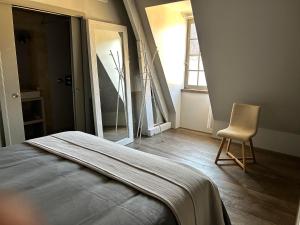 - une chambre avec un lit, une chaise et une fenêtre dans l'établissement Le Balconnet, à Sarlat-la-Canéda