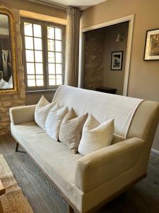- un canapé blanc avec des oreillers dans le salon dans l'établissement Le Balconnet, à Sarlat-la-Canéda