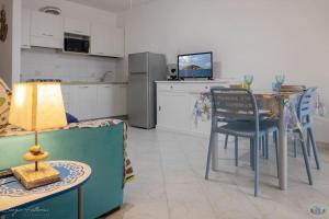 a living room with a table and a kitchen with a couch at Cav la Ginestra vistamare Elba in Rio nellʼElba +29 photos