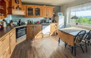 a kitchen with wooden cabinets and a table with a tableablish at Beautiful Home In Bogen I Ofoten With Wifi in Bogen