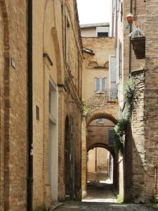 an alley between two brick buildings with an archway at Appartamento compagnoni in Macerata