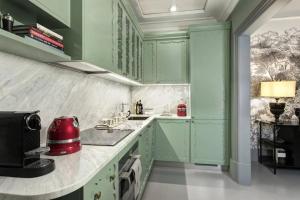 cocina con armarios verdes y microondas en Luxury Flat, en Londres