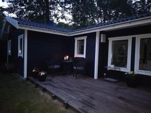 a deck with a table and chairs on a house at Holiday house, one hour away from Copenhagen, pets allowed, 4 rooms in Jægerspris