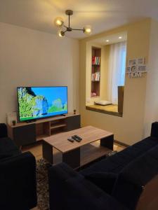 a living room with a television and a coffee table at ORA-PRN,peaceful central apartment in Pristina