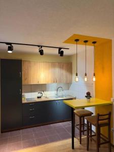 a kitchen with a sink and a table with chairs at ORA-PRN,peaceful central apartment in Pristina