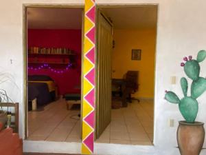 um quarto com uma parede amarela e rosa em Calli Tonanzin em Tepoztlán