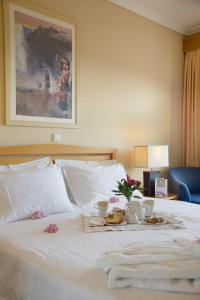 a white bed with a tray of food on it at Egnatia City Hotel & Spa in Kavala