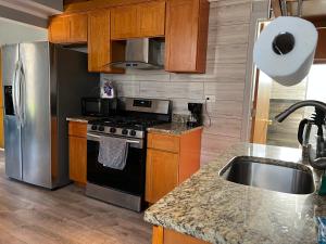 a kitchen with a stove and a stainless steel refrigerator at Ethan 3 rooms in Chicago