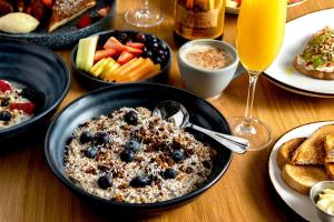 a table with a bowl of oatmeal with blueberries and bread at Noelle in Nashville