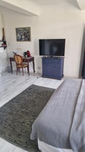 sala de estar con TV y cómoda azul en Le Mas du Sud, en Draguignan