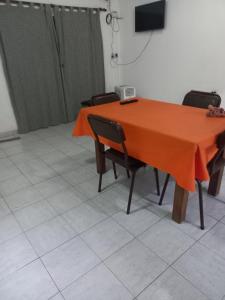 ein Tisch mit Stühlen und einer orangefarbenen Tischdecke darauf in der Unterkunft Don José in Villa Mercedes