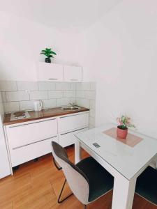 cocina con mesa, sillas y encimera blanca en Apartments Jagoda, en Split