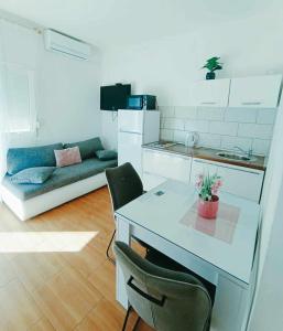 cocina con mesa, sillas y sofá en Apartments Jagoda, en Split