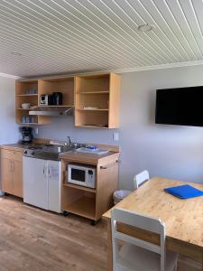 a kitchen with a table and a tv in a room at Chalets Glenn in Perce