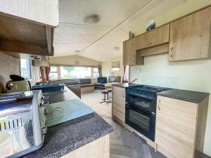 a kitchen with a stove and a counter top at Homely 8 Berth Caravan On A Great Holiday Park, Ref 46695v in Great Clacton