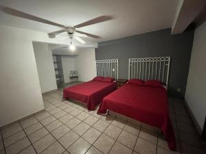 een slaapkamer met 2 bedden en een plafondventilator bij HOTEL JERUSALEM in San Juan de los Lagos