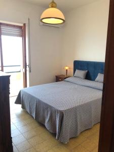 1 dormitorio con 1 cama con cabecero azul y ventana en Il Rifugio sul Mare, en Terme Luigiane