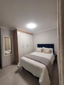 a bedroom with a large bed and a mirror at Two Bedroom Apartment in Durban