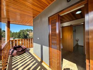 Un balcón de una casa con puerta de madera en Raio de Sol na Montanha en Campos do Jordão