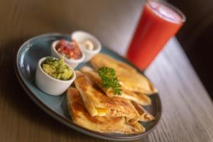 a plate of food with picoils and salsa and a drink at Hotel Zima in San Isidro de El General