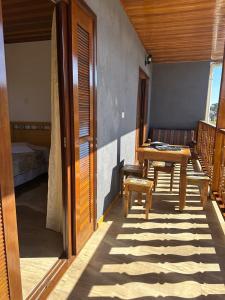 a room with a table and chairs on a patio at Raio de Sol na Montanha in Campos do Jordão