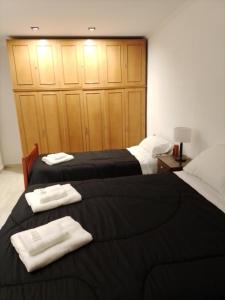 sypialnia z 2 łóżkami i ręcznikami w obiekcie RuGra Departamento w mieście Tres Arroyos