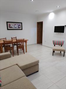 uma sala de estar com um sofá, uma mesa e cadeiras em RuGra Departamento em Tres Arroyos