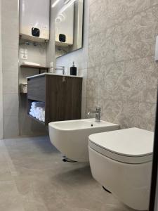 La salle de bains est pourvue de toilettes blanches et d'un lavabo. dans l'établissement Maison Chic Montenero Marina, à Marina di Montenero