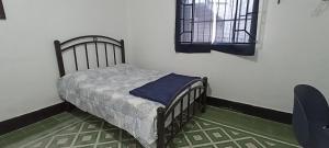 a small bed in a room with a window at Hostal Casa Azul, sencilla in Orizaba