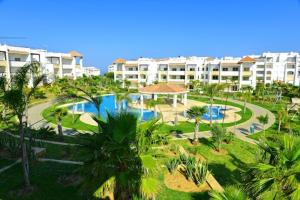 a view of a resort with a pool and buildings at Asilah Marina Golf in Asilah
