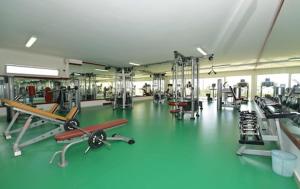 a gym with a green floor and machines in it at Asilah Marina Golf in Asilah