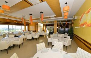 a dining room with white tables and white chairs at Asilah Marina Golf in Asilah