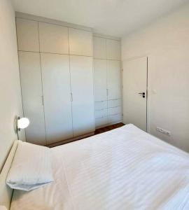 een slaapkamer met een groot wit bed en kasten bij Mokotów Prime Apartment in Warschau