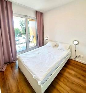 een slaapkamer met een groot bed en een groot raam bij Mokotów Prime Apartment in Warschau