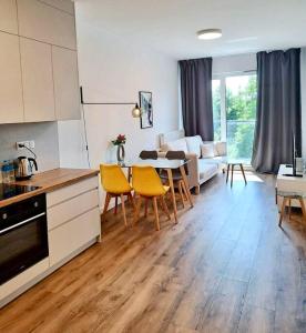 een keuken en een woonkamer met een tafel en stoelen bij Mokotów Prime Apartment in Warschau