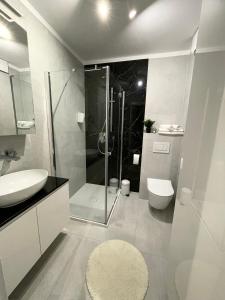 a bathroom with a shower and a toilet and a sink at K&M Apartament Panorama in Bochnia