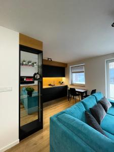 a living room with a blue couch and a kitchen at K&M Apartament Panorama in Bochnia