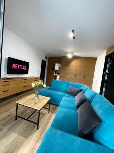 a living room with a blue couch and a table at K&M Apartament Panorama in Bochnia