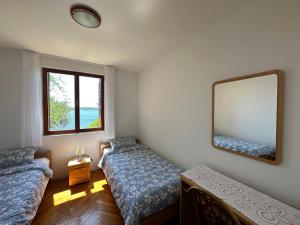 a room with two beds and a mirror on the wall at Villa Porthos in Hvar