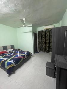 1 dormitorio con 1 cama y TV en Elvina Guesthouse @ Laguna Condo Resort PD en Kampong Tanah Merah
