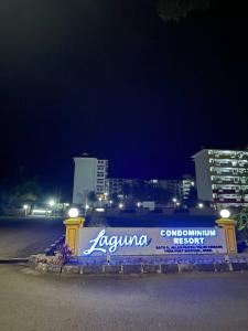un signo azul y blanco a un lado de una carretera en Elvina Guesthouse @ Laguna Condo Resort PD en Kampong Tanah Merah