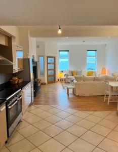 eine Küche und ein Wohnzimmer mit Sofas und einem Tisch in der Unterkunft 5 Shore Street in Donaghadee