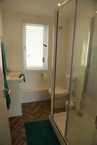 a bathroom with a toilet and a glass shower at 406 Sea View Road in Bridlington