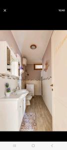 ein weißes Badezimmer mit 2 Waschbecken und 2 WCs in der Unterkunft LIEBE HOUSE in Sestu