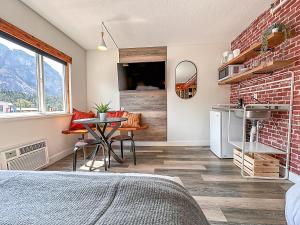 a bedroom with a brick wall and a table at Crash Hotel Squamish in Squamish
